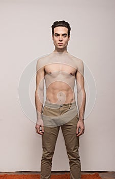 Young man model shirtless body posing pants