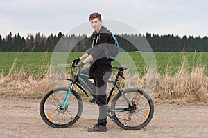 Young man on mountain bike on spring trip.