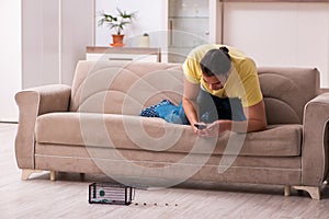 Young man and mousetrap at home