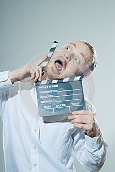 Young man with movie clapper