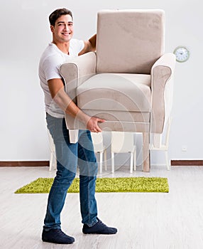 Young man moving furniture at home