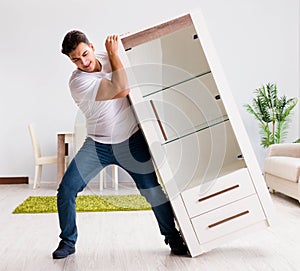 Young man moving furniture at home