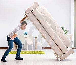 Young man moving furniture at home