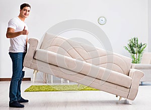 Young man moving furniture at home