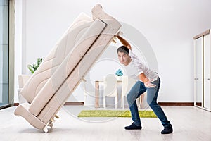 The young man moving furniture at home