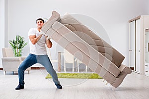 The young man moving furniture at home