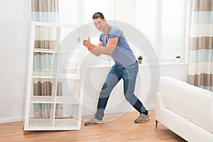 Young Man Moving Shelf