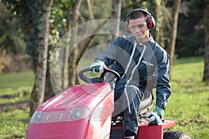 Young man mowing grass