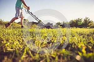 Young man mowing the grass