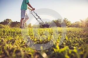 Young man mowing the grass