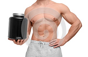 Young man with muscular body holding jar of protein powder on white background, closeup