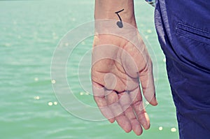 Young man with a musical note painted in his wrist