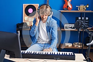 Young man musician composing song at music studio