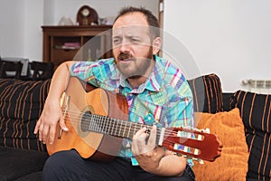 Young man musician playing acoustic guitar