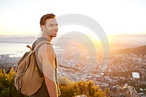 Young man on nature trail with a view of city