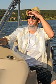 Young man navigating powerboat sunny