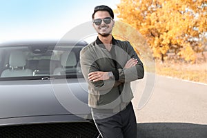 Young man near modern car on sunny day l