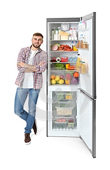 Young man near open refrigerator