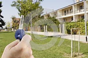 Young man and new home, door key in hand