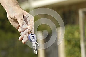 Young man and new home, door key in hand