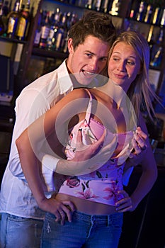 Young man in a nightclub grabbing breasts photo