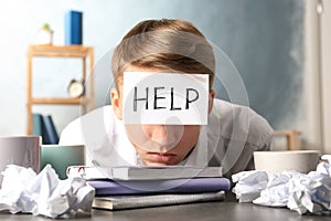 Young man with note HELP on forehead