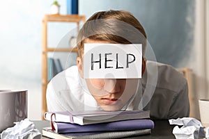 Young man with note HELP on forehead