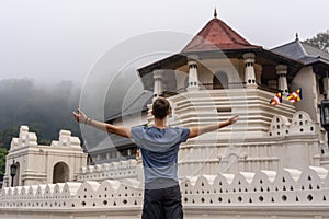 The young man observe Sri Dalada Maligawa temple in Kandy, Sri Lanka