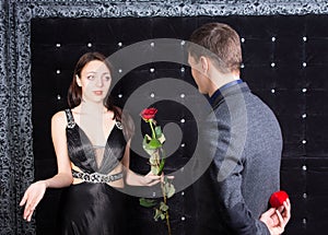 Young Man Offering a Flower to Unhappy Lady