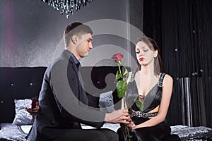 Young Man Offering Rose Flower to Sad Girlfriend