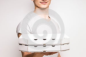 Young man offers boxes with pizza.