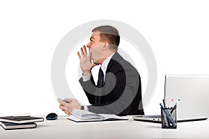 Young man in office shouting with hands cupped to his mouth isolated on white background