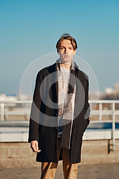 Young man in old wool coat, scarf and short trousers outdoor