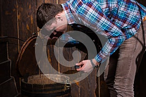 Young man opened a barrel and trying to solve a conundrum to get