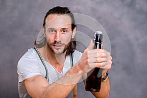 Young man opening a beer bottle
