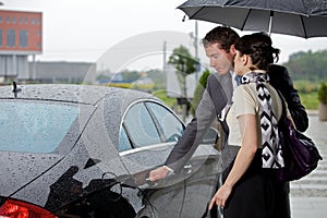 Young man opening door of car for woman