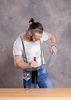 Young man opening red wine