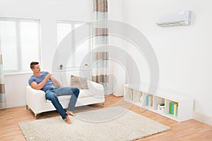 Young Man Operating Air Conditioner photo