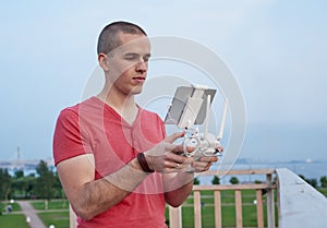 Young man operating a drone remote control console