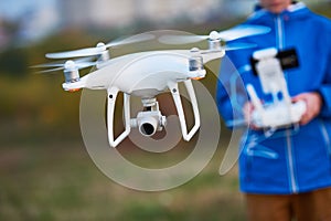 Young man operating of flying drone at sunset