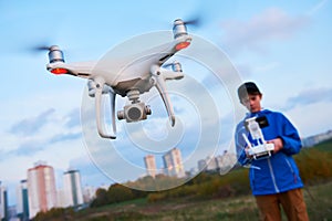 Young man operating of flying drone at sunset