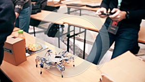 Young man operating his DIY hexapod robot using cell phone