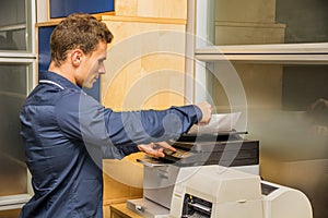 Young Man Operating Photocopier Machine