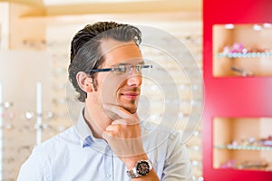 Young man at optician with glasses