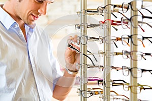 Young man at optician with glasses