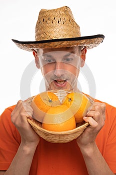 Young man with oranges on white