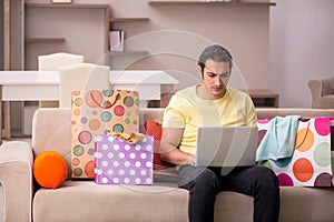 Young man ordering giftboxes via Internet