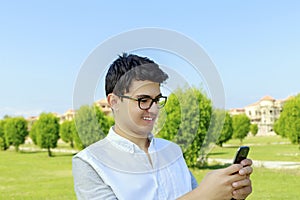 Young man outdoor with great smile playing on smart phone.