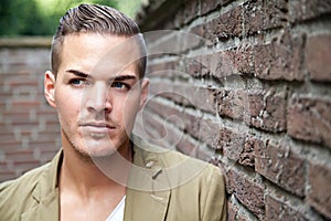 Young man outdoors against a wall