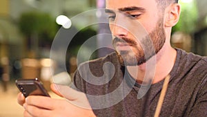 Young man outside at night watching video on phone